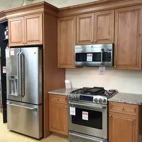 kitchen showroom with wooden cabinets and stainless steel kitchen appliances on display