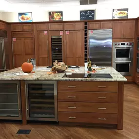 kitchen appliance showroom with wooden cabinetry, a kitchen island, and built in kitchen appliances