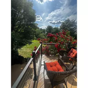 This beautifully painted wood deck features stylish cable railings, combining traditional craftsmanship with contemporary design elements for a stunning outdoor space.