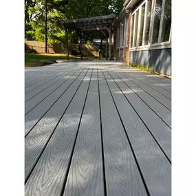 This sleek composite Trex deck showcases a gray finish with wood grain patterns, creating a beautiful, low-maintenance outdoor living space.