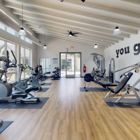 a gym with exercise machines and a TV