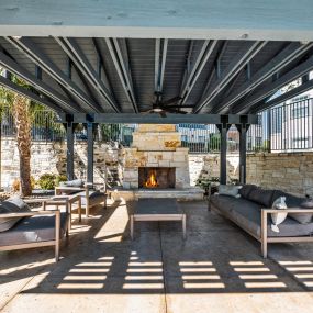 a patio with couches and tables and a fireplace