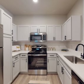 a kitchen with white cabinets and stainless steel appliances