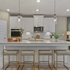 Gourmet kitchen with white cabinets and island in DRB Homes Riverbend Overlook