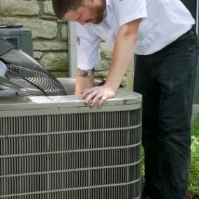 Tyson Services Technician Cleaning Inside of Outdoor Unit