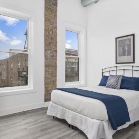 Exposed brick in spacious bedroom