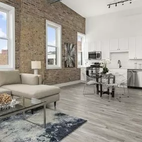 Living room with exposed brick wall and hardwood floors