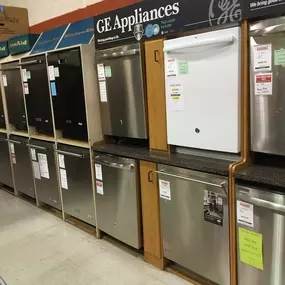 Dishwasher showroom with multiple dishwashers lined up for display and tile flooring