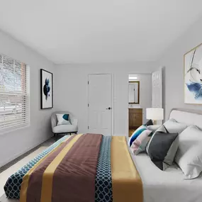 A bedroom with a bed, a chair, and a painting on the wall.