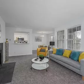 A living room with a grey couch and a fireplace.