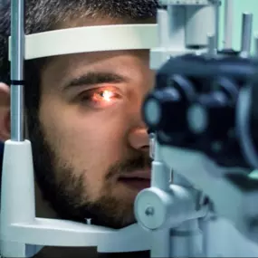 Man receiving an eye exam through a slit lamp