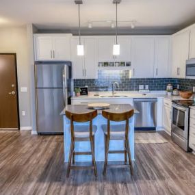 a kitchen with stainless steel appliances and two bar stools