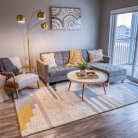 a living room with a couch and a table with a rug