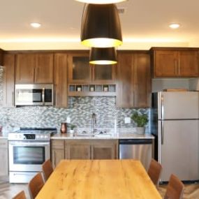 a kitchen with stainless steel appliances and a wooden table