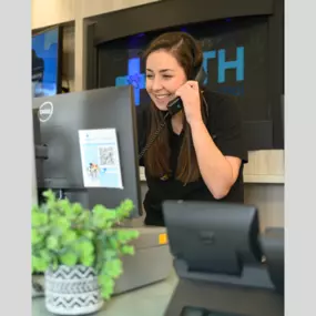 A team member at Oath Animal Hospital, East Meadow, NY, answering client calls at the front desk.