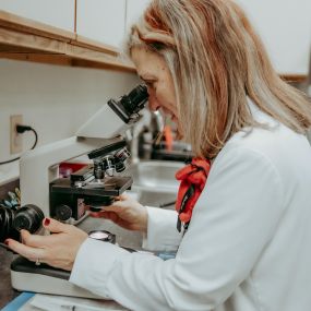 Dr. Rudd examines a specimen under a microscope.