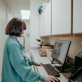 Veterinary technician, Mary, is hard at work logging patient information.