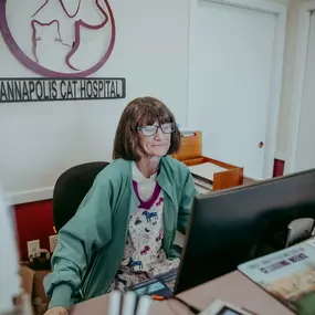 Veterinary technician, Mary, mans the cat desk with. a smile.