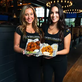 P.J. Whelihan's servers holding wings and fries