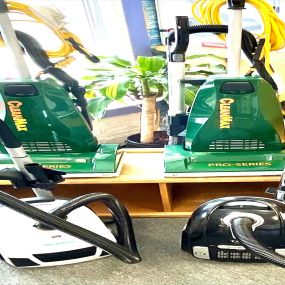 In the Bozeman showroom of Imperial Vacuum and Appliances, 2 green Clean Max upright vacuums and 2 Simplicity canister vacuums are elegantly displayed, showcasing their sleek designs and features.