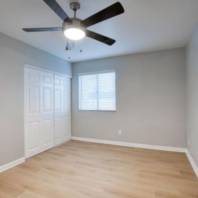 spacious bedroom with ceiling fan and closet