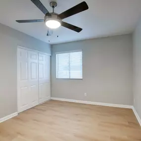 Spacious bedroom with ceiling fan and closet
