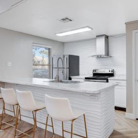 clubroom kitchen with barstool seating and white countertops