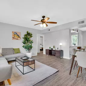 modern living room with a ceiling fan, couch, and dining table