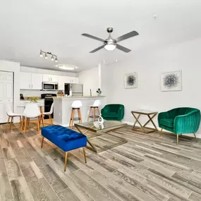 spacious living room with ceiling fan and chairs