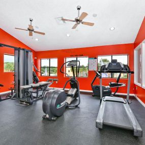 fitness center with a treadmill, elliptical, and machine weights