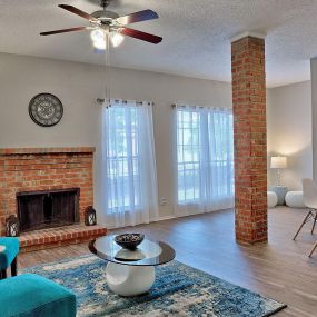 spacious living room with couch and brick fireplace