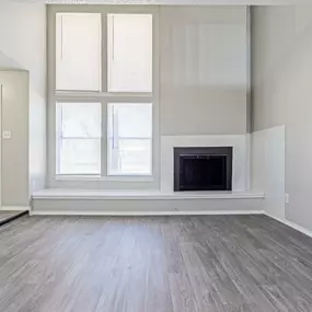 living room with tall ceiling, large windows, and a fireplace