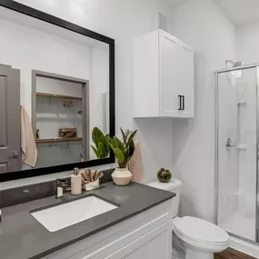 Bathroom with a large window, a toilet sink, and a shower