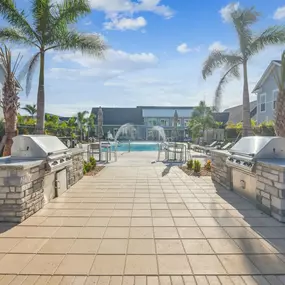 A grill station with a pool in the background