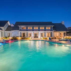 A large swimming pool with a house in the background