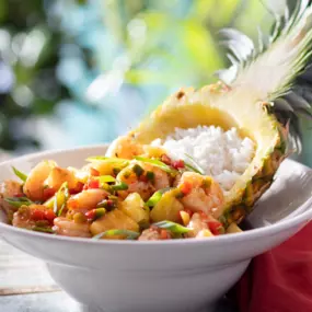 Shrimp Pineapple Bowl - Sautéed shrimp, white rice, diced pineapples and sweet peppers tossed in a jerk pineapple glaze. Served in a fresh-cut pineapple bowl.