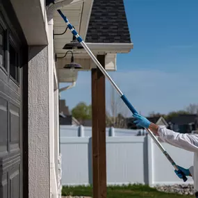 Our comprehensive exterior pest control services protect your Boise home from common pests. In this image, a certified First Line Pest Defence technician is applying a preventative treatment to the roofline and eaves, an area where spiders, wasps, and other insects often build nests and webs. This proactive approach is part of our standard treatment plan to create a protective barrier around your property, keeping pests out before they become a problem. Trust our team to provide thorough, profes