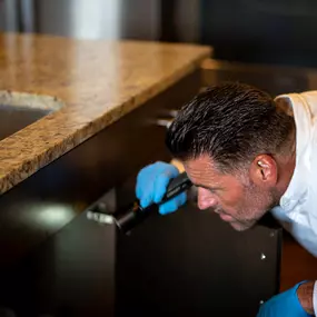 A First Line Pest Defense technician performs a comprehensive pest inspection in a Boise, ID residence. Our specialists meticulously examine common pest harborage areas, such as under kitchen sinks, using professional tools to accurately identify any signs of infestation. This detailed inspection process is the first step in creating a targeted, effective treatment plan to protect your home and family.