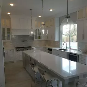 Top row of cabinets are a great way to to make your kitchen cabinets stand out, when you have a high ceiling.  This kitchen was 10 feet height. We started of with normal height cabinets and then added a top row of  glass cabinets with ligths inside and a nice hood trim. Also we added a nice crown molding to trim it up. Customer decided to Reuse the existing appliances.  For countertop we used premium 
Calacata quartz and full  tile backslash.