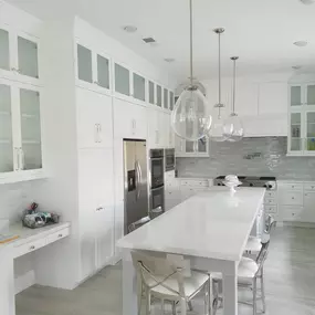 Top row of cabinets are a great way to to make your kitchen cabinets stand out, when you have a high ceiling.  This kitchen was 10 feet height. We started of with normal height cabinets and then added a top row of  glass cabinets with ligths inside and a nice hood trim. Also we added a nice crown molding to trim it up. Customer decided to Reuse the existing appliances.  For countertop we used premium 
Calacata quartz and full  tile backslash.