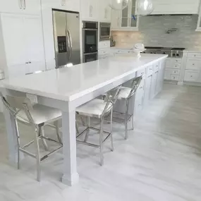 Top row of cabinets are a great way to to make your kitchen cabinets stand out, when you have a high ceiling.  This kitchen was 10 feet height. We started of with normal height cabinets and then added a top row of  glass cabinets with ligths inside and a nice hood trim. Also we added a nice crown molding to trim it up. Customer decided to Reuse the existing appliances.  For countertop we used premium 
Calacata quartz and full  tile backslash.