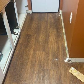 Pictured here is Siren Wisconsin water damage restoration in a basement “Mother-in-Law Kitchen.”   In this picture, we are removing the flooring and floor trim to mitigate the mold.