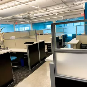 A photograph displaying the organized cubicle workspace within M&M Private Lending Group's office, illustrating the collaborative environment where loan specialists assist clients.