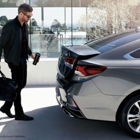 Man with the unlocked trunk of his Hyundai makes loading things simple even when he has his hands full