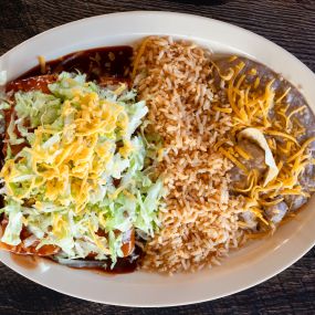 2 cheese or chicken enchiladas topped with crisp lettuce and covered in our rich enchilada sauce all served with a side of seasoned rice and refried beans. Includes rice and beans.