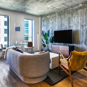 A living room with a couch, chair, and television