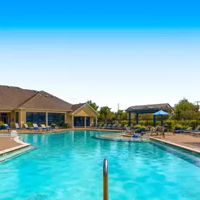 Swimming pool with chairs and umbrellas at the club house