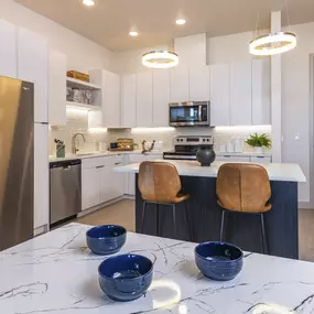 a kitchen with stainless steel appliances and quartz counter tops