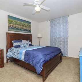 a bedroom with bed side table and lamp