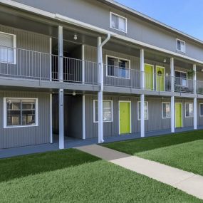 exterior of apartments with grey paint and yellow doors